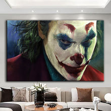 Load image into Gallery viewer, Rolled tube packaging for canvas prints laid on a wooden surface with pink decorative leaves.